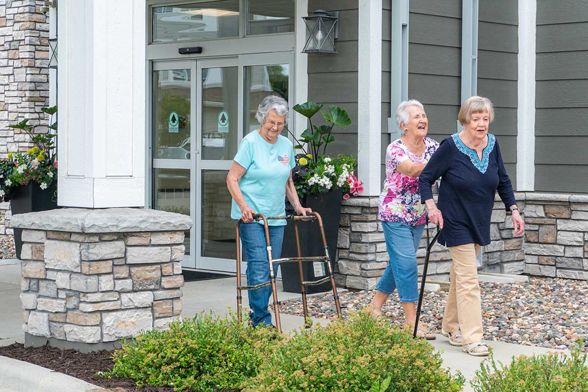A Group Of Older Women Walking With Walker